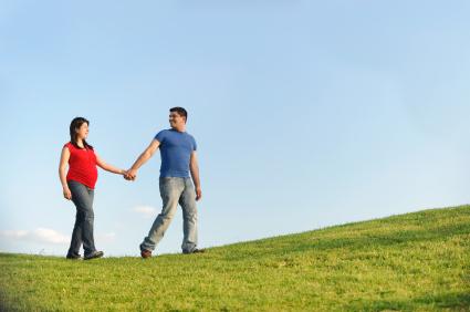 pregnant woman holding hands and walking with man